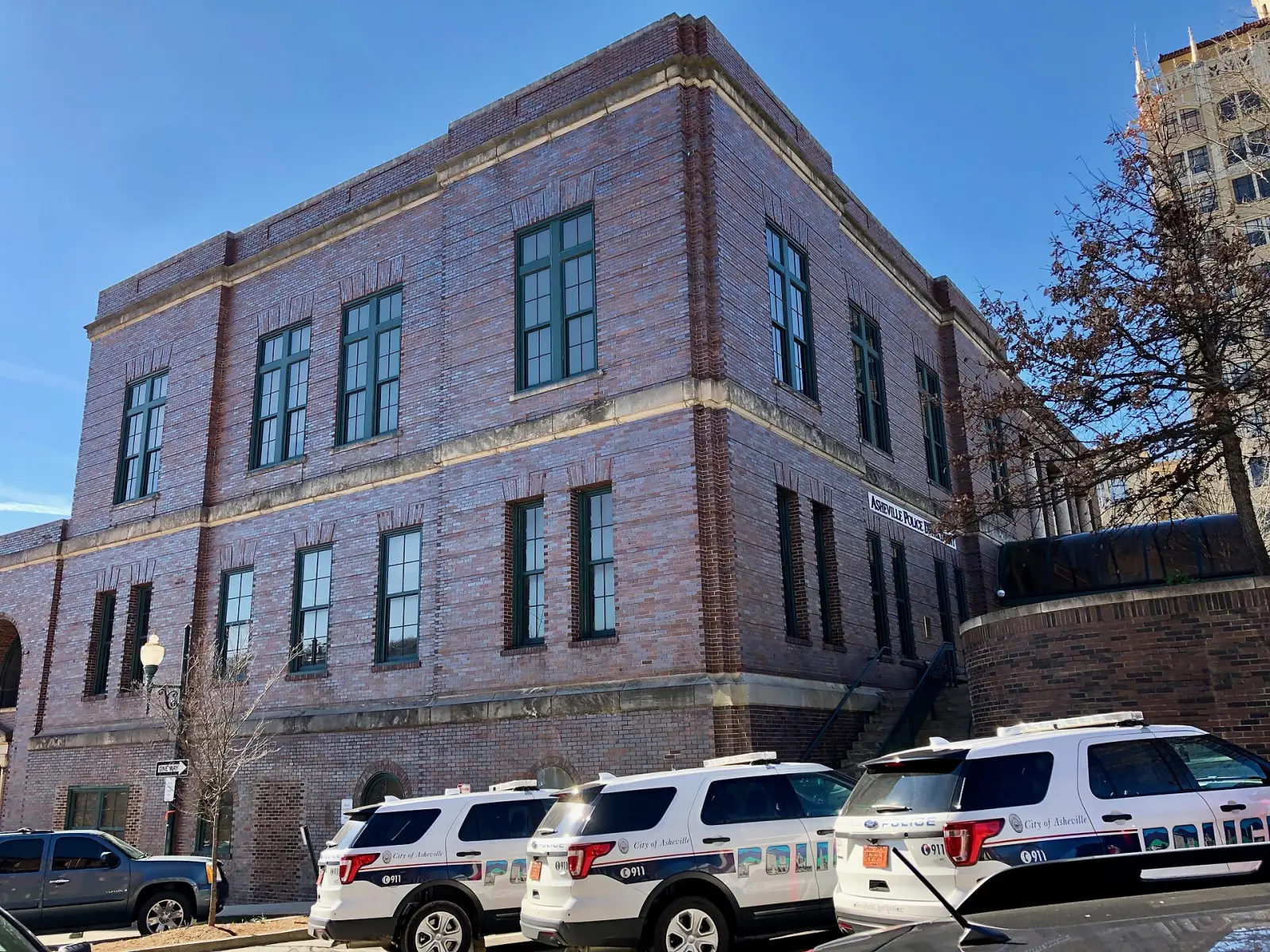The Asheville Municipal Building, with marked City police vehicles parked beside it.