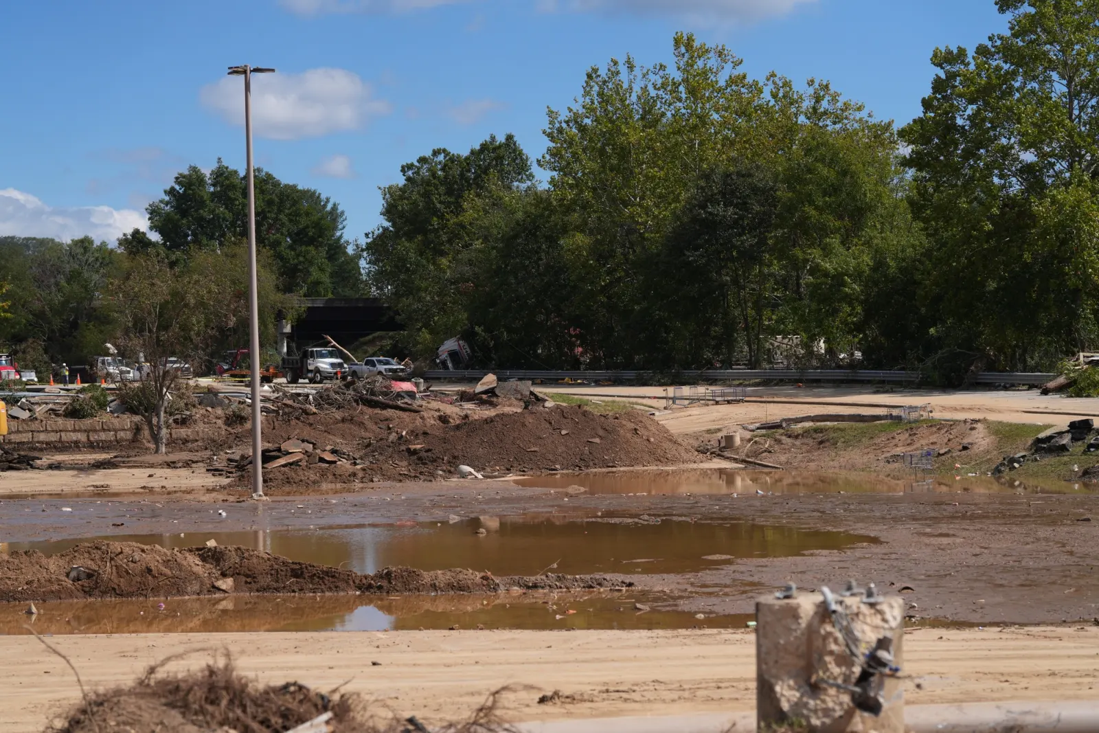 Debris caught on buildings above a mud-covered lot, marking how high the flood reached.